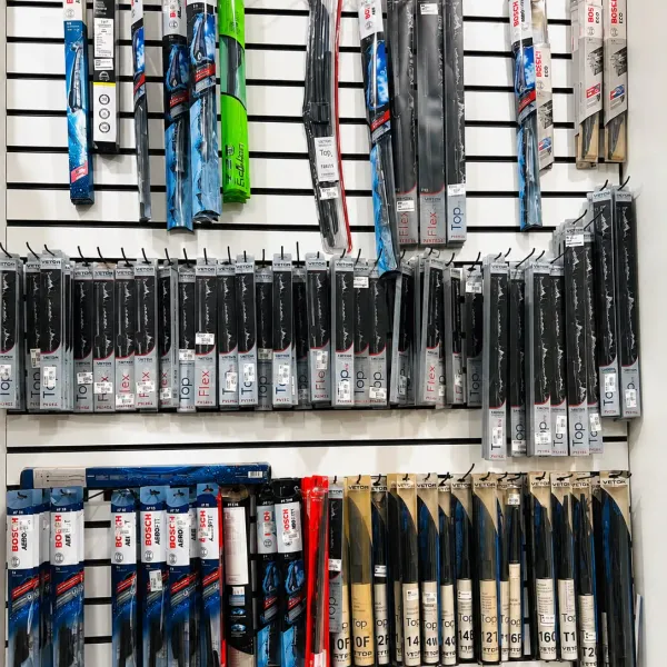 Painel branco com dezenas de palhetas de limpador de para-brisa das marcas Bosch e Vetor penduradas por tamanho
